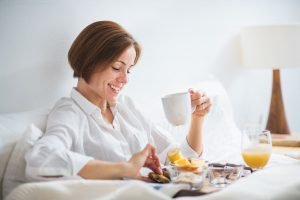 A woman having breakfast in bed in the morning.