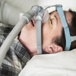 A woman sleeping with anti snoring chin strap