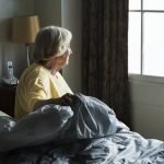 Senior woman sitting in a bedroom