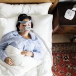 Woman sleeping with an anti-snoring mask